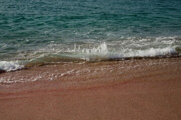 Wall Mural - a beach scene with waves rolling in and out of the water