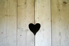 Closeup Shot Of A Heart Shaped Hole In A Wooden Door