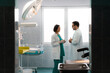 © Dorde - Two serious doctors in uniforms talking face to face with hands in front, while standing in hospital room.