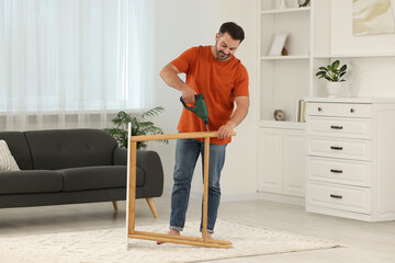 Poster - Man with electric screwdriver assembling shoe storage bench at home