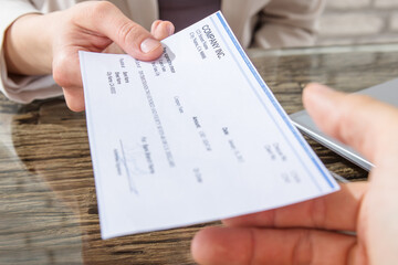 Businesswoman Giving Cheque To Her Colleague