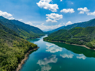 Wall Mural - Aerial photography of a large reservoir with blue sky and white clouds and mountains