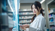 © DY - Pretty Asian woman examining drugs in a pharmaceutical company's laboratory