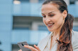 © carballo - attractive business woman on the street looking at mobile phone