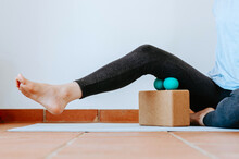 Person Doing Self Myofascial Release Of Hamstrings With Two Massage Balls On Cork Block	