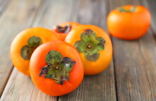 Persimmons On Wooden Table