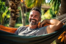Handsome Middle-aged Man Relaxing In Hammock At Tropical Resort