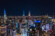 Thousands of lights in large city at night. Aerial panoramic shot of high rise colour illuminated buildings. Manhattan, New York City, USA