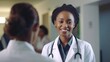 © Fred - Smiling black female doctor talking to her colleagues