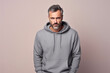 Anger European Man In Gray Sweatshirt On Pastel Background
