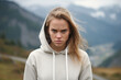 Anger European Woman In Beige Hoodie On Mountain Scenery Background