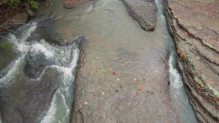 Wall Mural - Multiple waterfalls flow over rock cascade in the Ozark mountains during autumn with fall colored forest tree leaves     