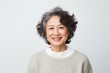 © Anne-Marie Albrecht - Medium shot portrait of a Chinese woman in her 50s in a white background wearing a cozy sweater