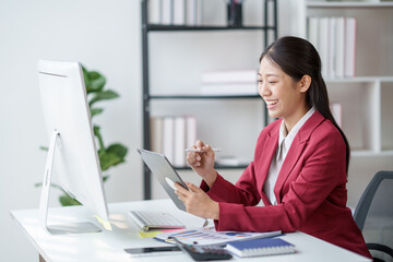 Poster - Asian businesswoman studying stock chart using digital tablet in office