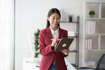 Poster - Asian businesswoman studying stock chart using digital tablet in office