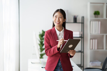 Poster - Asian businesswoman studying stock chart using digital tablet in office
