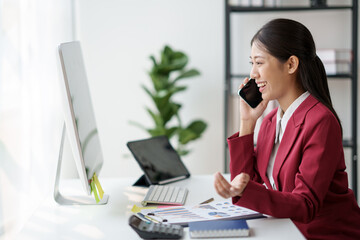 Poster - Asian businesswoman talking on the phone about business issues in the office