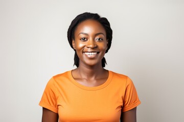 Wall Mural - Close-up portrait of a Nigerian woman in her 30s in a white background wearing a casual t-shirt