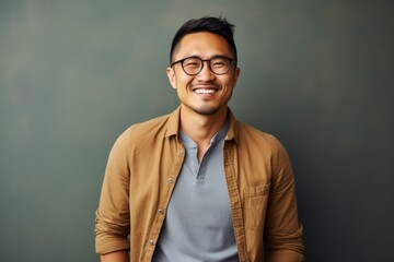 Wall Mural - Lifestyle portrait of a Chinese man in his 30s in a minimalist or empty room background wearing a chic cardigan