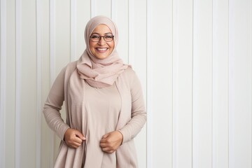 Wall Mural - Portrait of happy muslim woman in hijab looking at camera and smiling