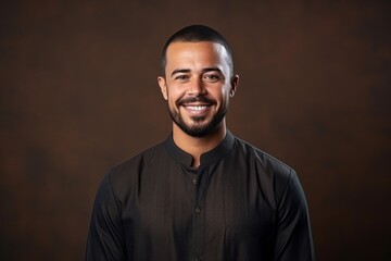 Wall Mural - Portrait of a handsome young african american man smiling against brown background