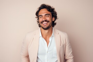 Wall Mural - Portrait of a handsome young man with curly hair smiling against white background