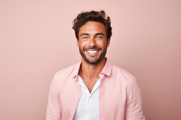 Wall Mural - Portrait of a handsome young man smiling at camera against pink background