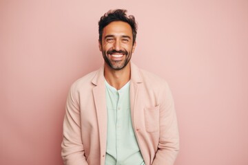 Wall Mural - Lifestyle portrait of a Brazilian man in his 30s in a pastel or soft colors background wearing a chic cardigan