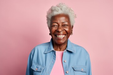 Portrait of happy senior african american woman laughing and looking at camera isolated over pink background