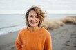 © Leon Waltz - Medium shot portrait of a Russian woman in her 40s in a beach background wearing a cozy sweater