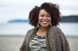 © Leon Waltz - Group portrait of a Nigerian woman in her 30s in a beach background wearing a chic cardigan