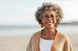 © Leon Waltz - Lifestyle portrait of a Nigerian woman in her 60s in a beach background wearing a chic cardigan