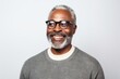 © Hanne Bauer - Portrait of a Nigerian man in his 50s in a white background wearing a chic cardigan