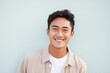 Portrait of a Indonesian man in his 20s in a pastel or soft colors background wearing a chic cardigan