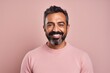 © Hanne Bauer - Portrait of a Saudi Arabian man in his 40s in a pastel or soft colors background wearing a chic cardigan