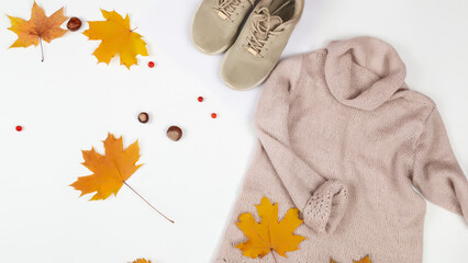 Wall Mural - Autumn composition. dried autumn leaves, sneakers, sweater on a white background. Flat lay, top view, copy space