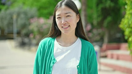 Poster - Young chinese woman smiling confident standing at park