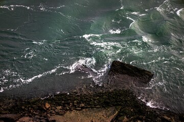 Sticker - Majestic seascape featuring large boulders rising from the tumultuous ocean waves