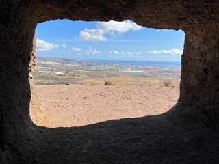 Wall Mural - View of a sunny deserted landscape from a window in a cave