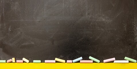 Closeup of a black chalkboard with chalks under the natural light