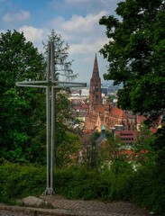 Canvas Print - Traditional cross in the foreground of a cobblestone road in a cityscape