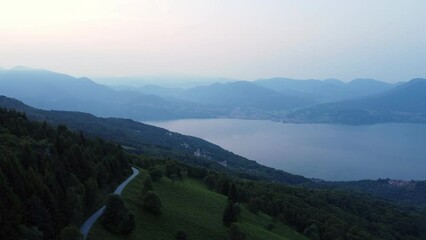 Sticker - Aerial landscape of green forested hills with a Oggebbio lake view at sunrise