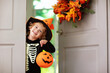 © famveldman - Kids trick or treat. Halloween. Child at door.