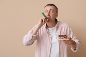 Poster - Mature man with party blower and piece of birthday cake on beige background