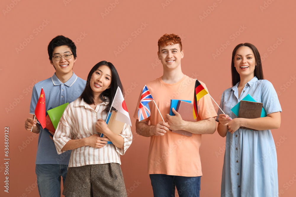 Young students of language school with flags on pink background