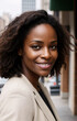 © Studio Abraham - Close-up of Successful African American Woman on a City Street, Wearing a Light Jacket, Looking at Camera From an Angle With Content Smile, AI