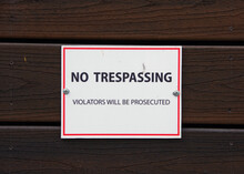 NO TRESPASSIGN Sign On A Wooden Building Wall