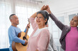 © kelvn - Group of senior people dancing and having fun at home, Happy moment with Group of Asian senior man and woman singing with fun togetherness in living room.