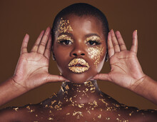 Cosmetics, Portrait And Black Woman With Gold Makeup On Brown Background With Glitter Paint. Shine, Glow And African Model In Studio For Beauty, Fashion Art And Aesthetic Freedom In Luxury Skincare.