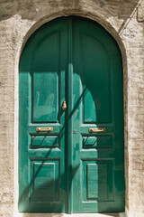 Old ancient colourful textured door in a stone wall in Greece, Crete. Vintage doorway. Traditional European, Greek architecture. Summer travel